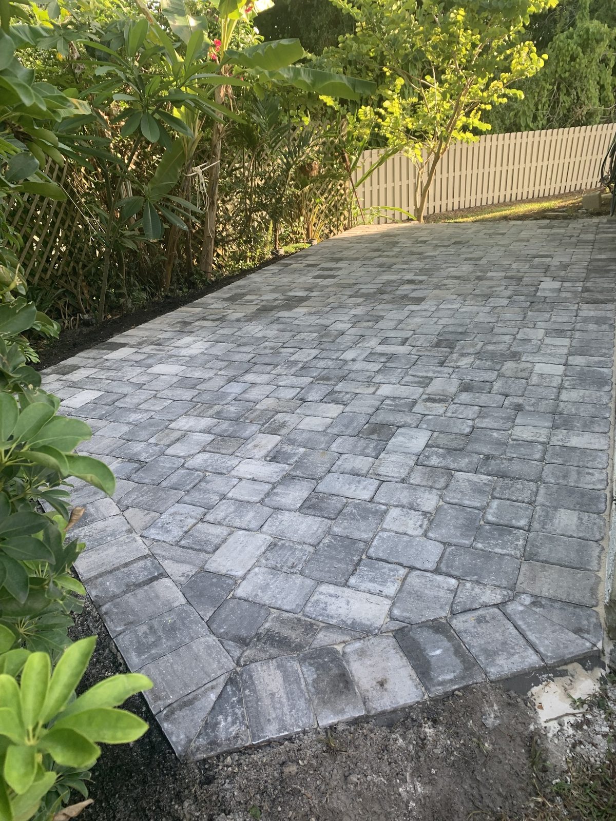 Gray paver walkway on a slope beside a house, On Pace Pavers
